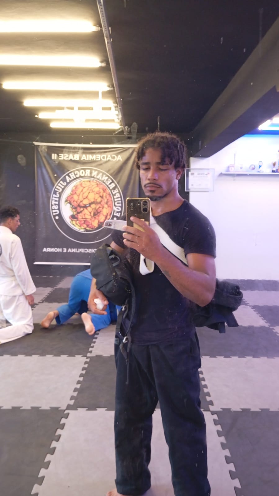 Christofer de kimono e faixa em treino de Jiu-Jitsu